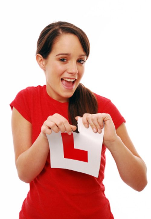 Teen driver holding learner sign